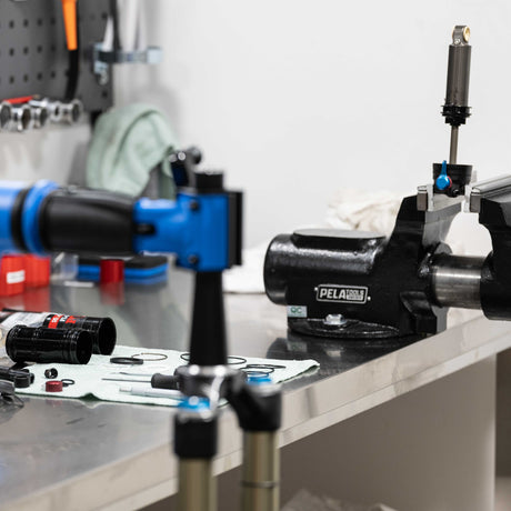 Cykelverktyg och delar på arbetsbänk med PELA-skruvstäd och servicekit