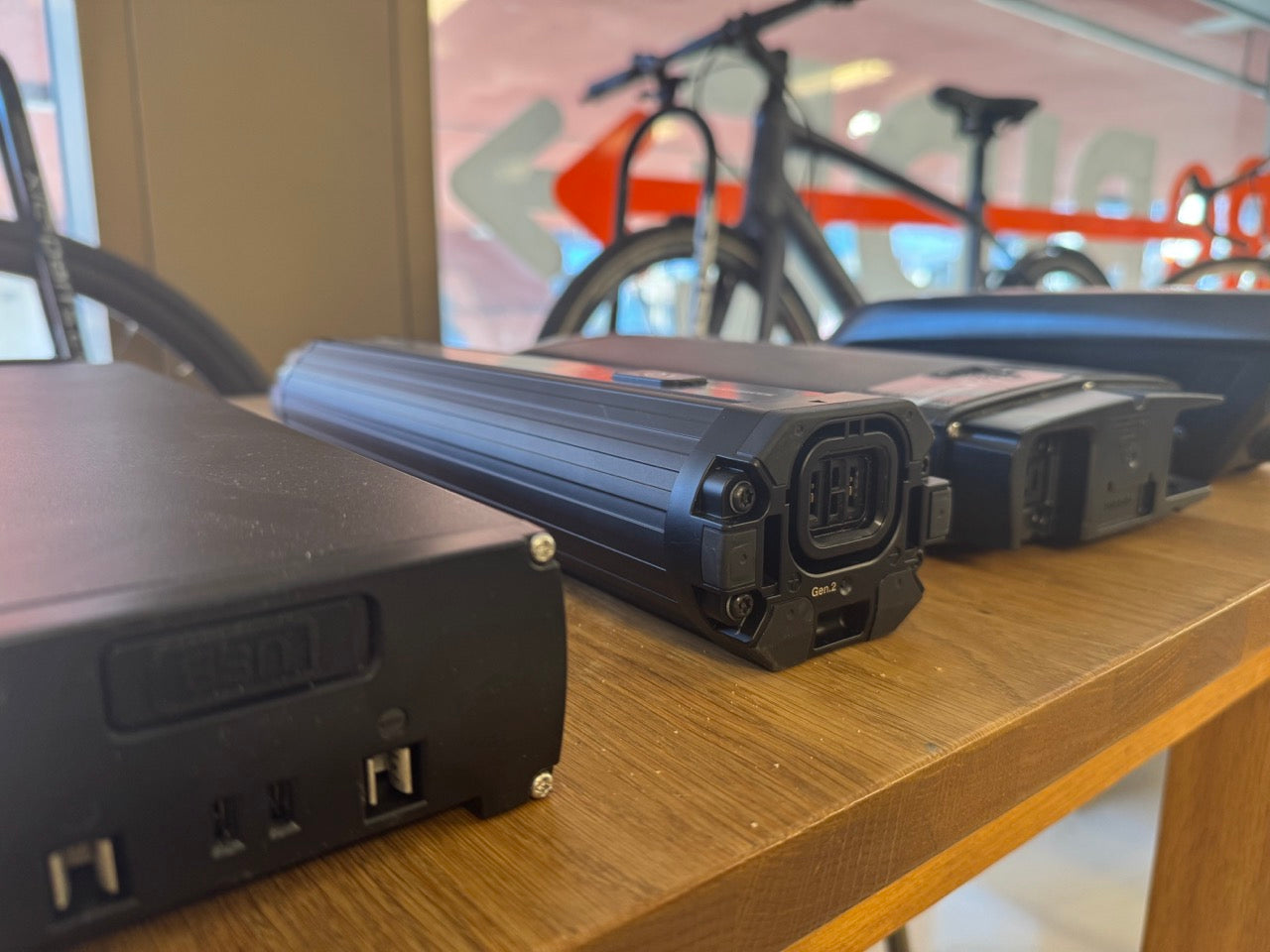 elcykelbatterier och laddare på träbord, elcykel synlig