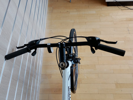 cykelstyre och bromshandtag på vit cykel, närbild framifrån