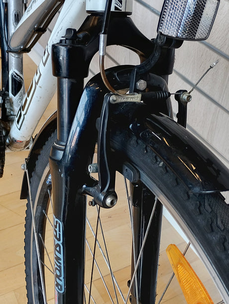 Framgaffel och V-broms på cykel med reflex och däck, SR SUNTOUR logotyp synlig.