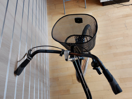 Cykelstyre med korg och svarta handtag, fokus på cykeltillbehör
