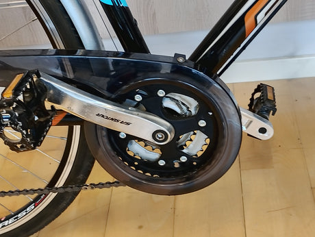 cykelpedal och Shimano-vevarm med kedjeskydd på sportcykel