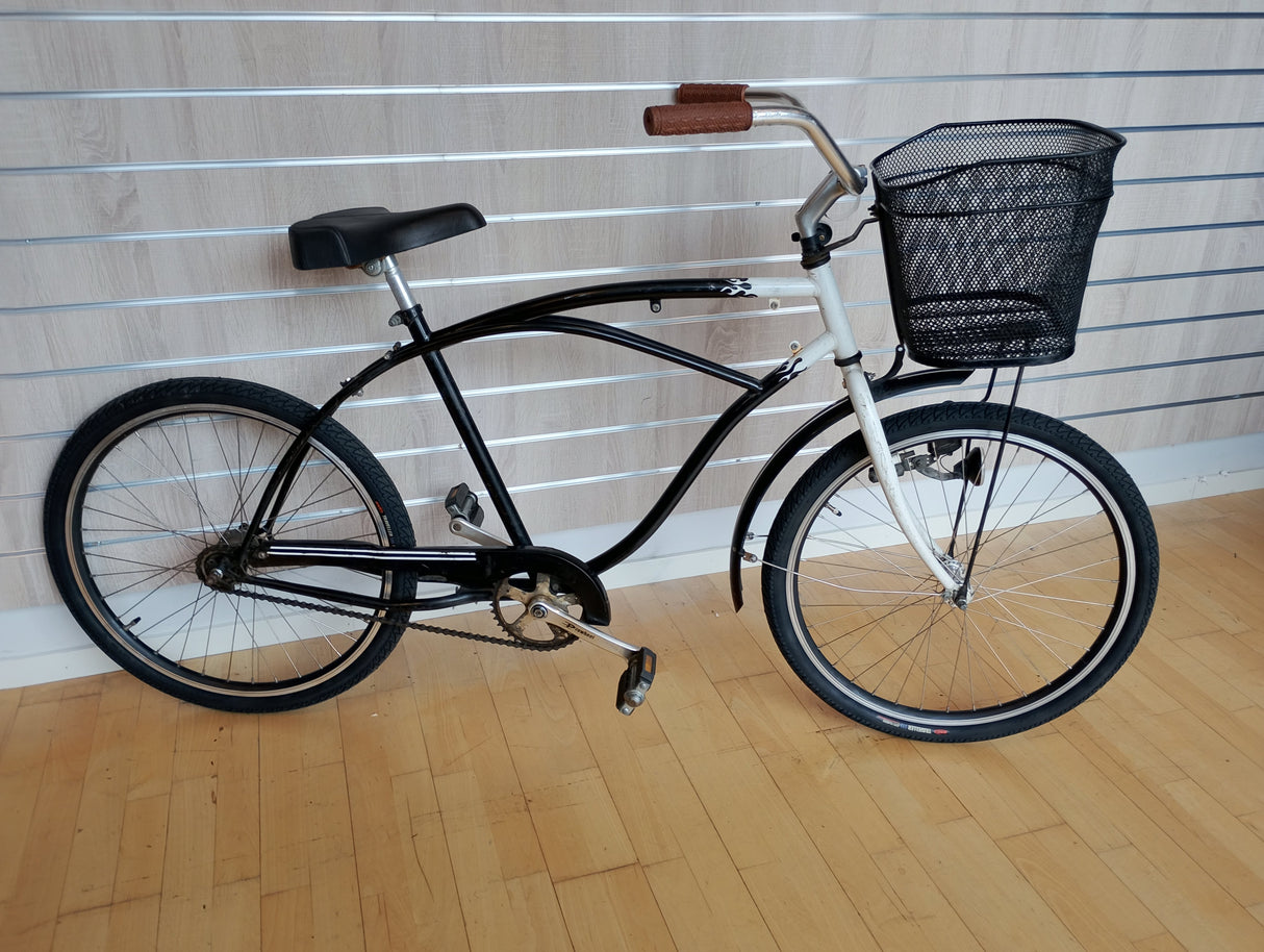 Svart cruiser-cykel med korg, bruna handtag och bred sadel