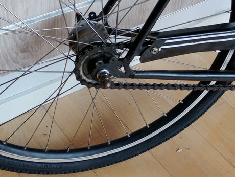 Cykelhjul bakhjul med kedja och ekrar på svart cykel, närbild