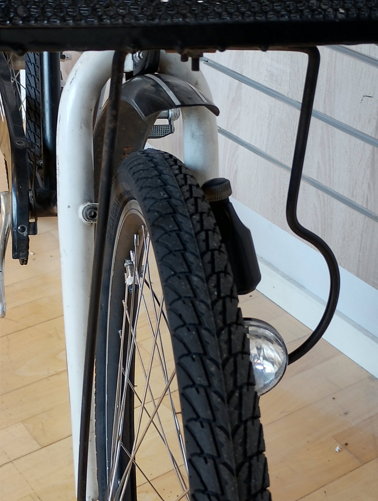 Cykel framhjul med skärm, däck, ekrar och dynamo lampa i närbild