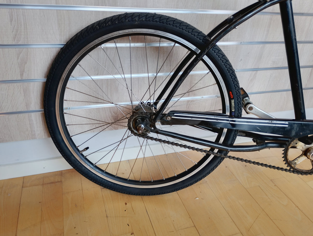 Bakdel av svart cykel med kedja och svart däck, cykelhjul detalj