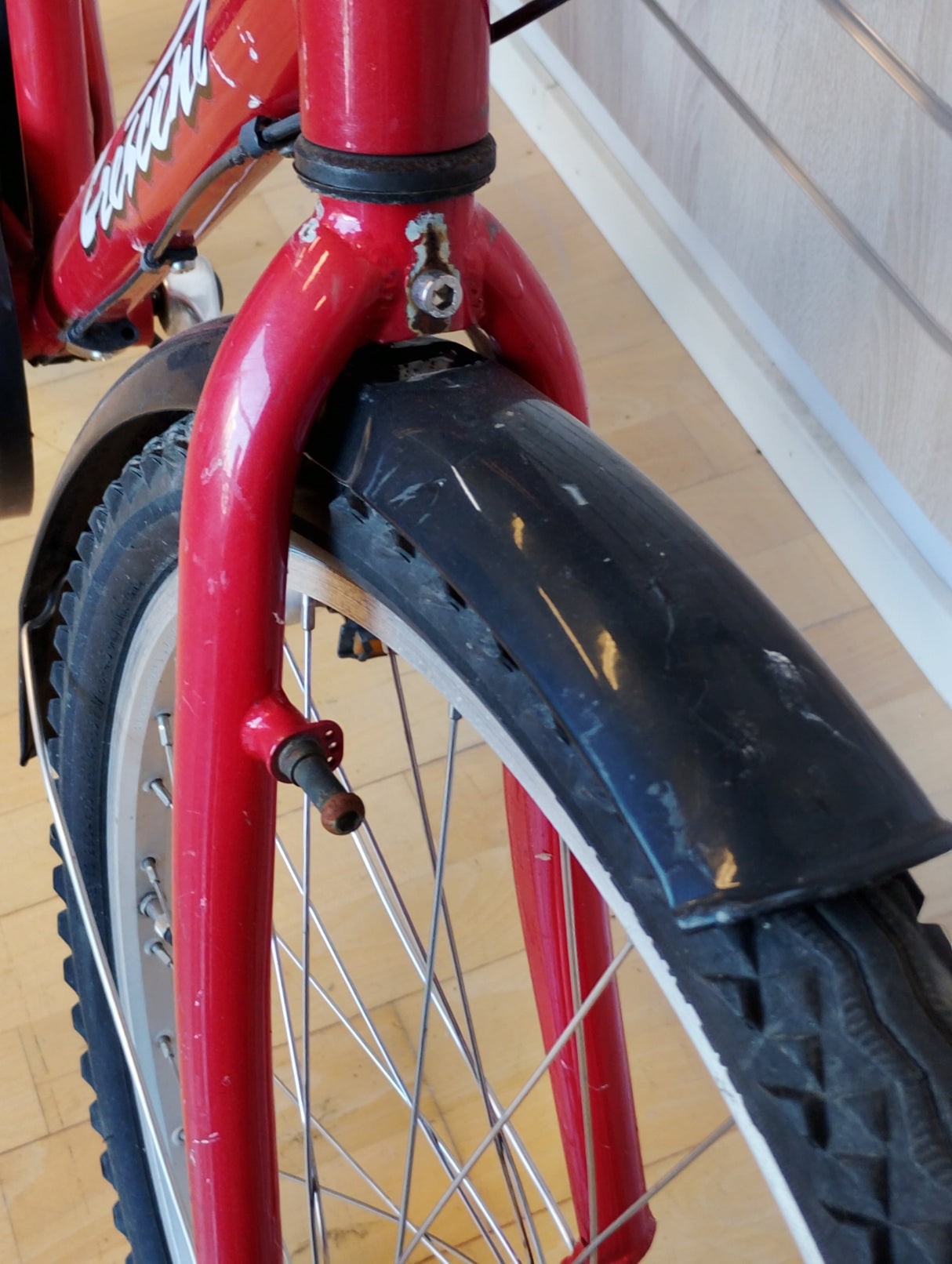 röd cykel framgaffel med svart skärm och grovt mönstrat däck