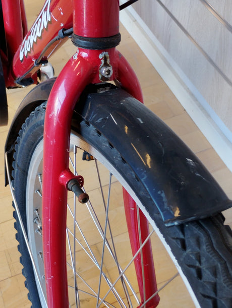 röd cykel framgaffel med svart skärm och grovt mönstrat däck