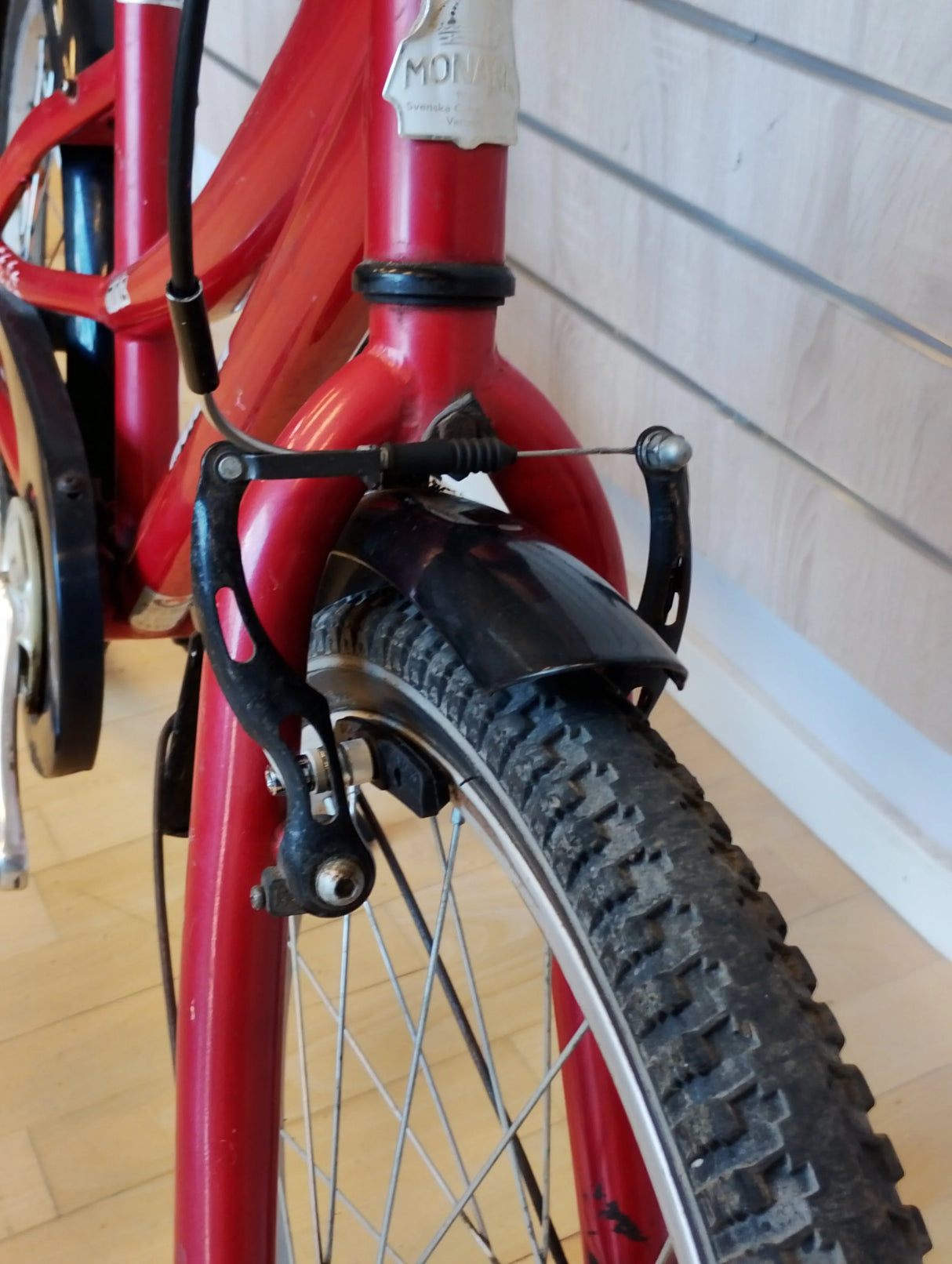 Röd Monark cykel framgaffel med däck, fälgbroms och stänkskydd