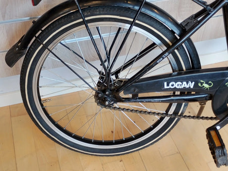 Bakdäck på Logan cykel med svart ram, kedjeskydd och vita däcksidor