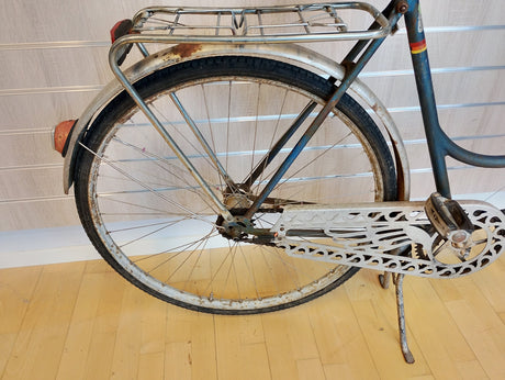 Bakdel och hjul på gammal cykel med pakethållare, rostiga detaljer, kedjeskydd