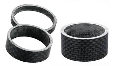 Tre svarta kolfiberspacer för cykelstyre med tydlig textur och rund form