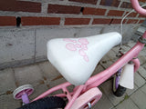 Barncykel i rosa med vitt säte dekorerat med rosa hjärtan och stödhjul