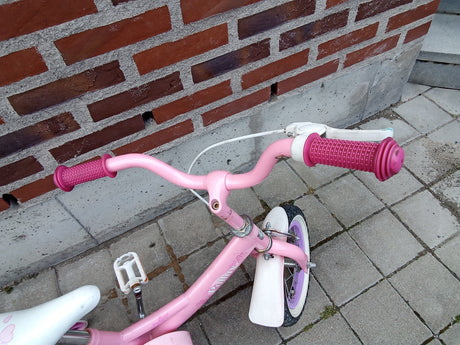 Barncykel i rosa med vita pedaler och lila hjul med skärm