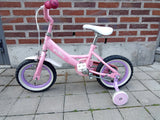 rosa barncykel med stödhjul, vita däckkanter och lila fälgar