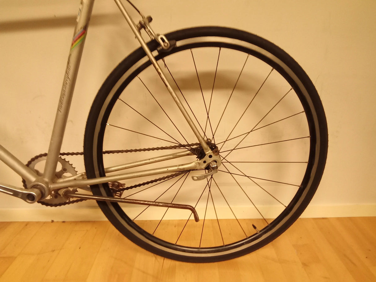 Bakre hjul och kedja på vintage silver cykel med smala däck och snabbkoppling