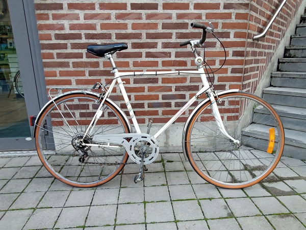 vintage vit cykel med bruna däck och svart sadel