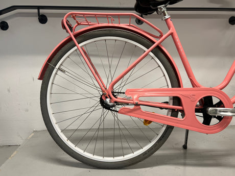 rosa cykel bakhjul med vit fälg, kedjeskydd och pakethållare