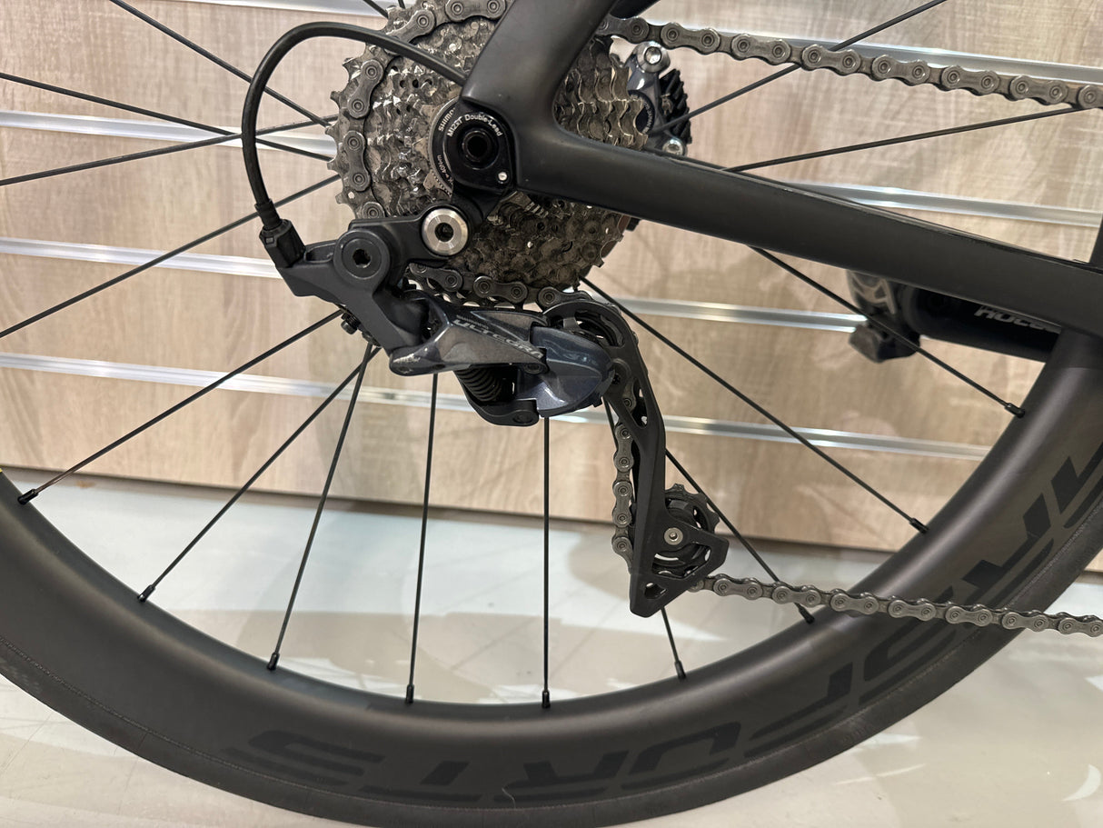Detaljbild på Shimanos Ultegra bakväxel och kassett på racercykelhjul med karbonfälg