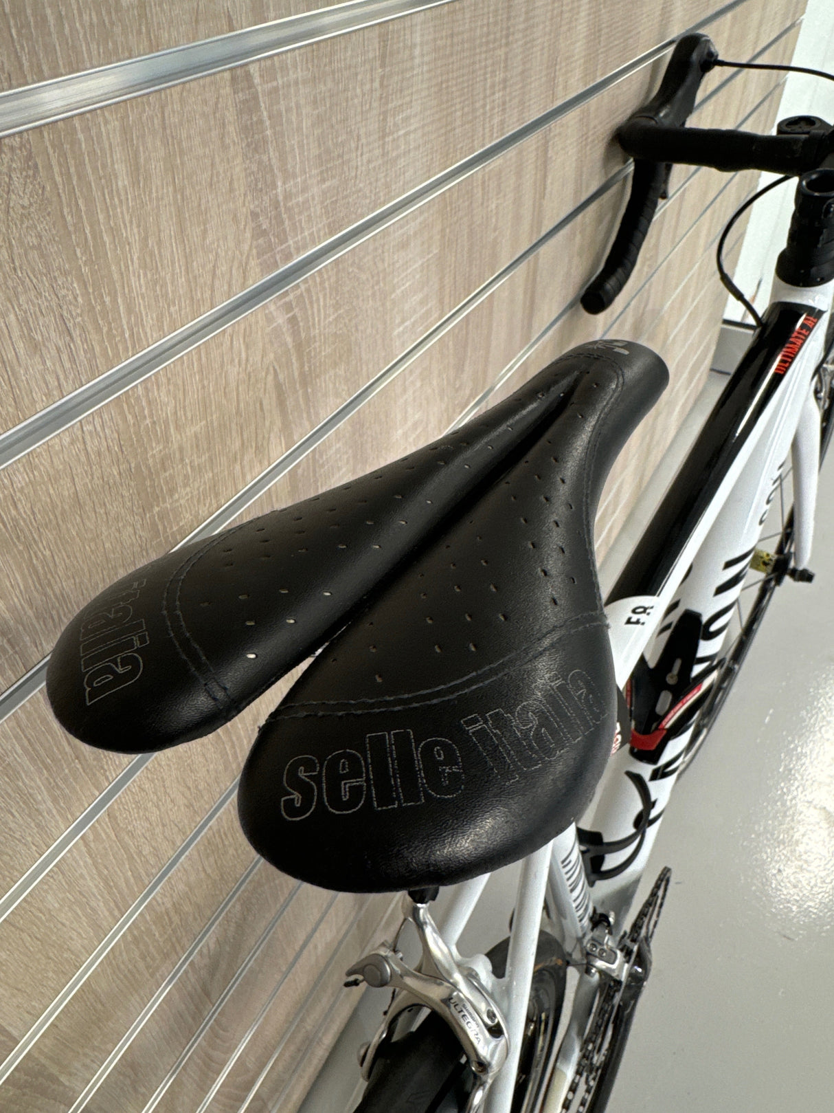 Selle Italia svart cykelsadel på vit och svart racercykel med droppstyre