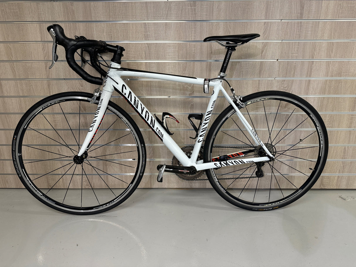 vit Canyon landsvägscykel med svart styre och sadel, hydrauliska bromsar och smala däck
